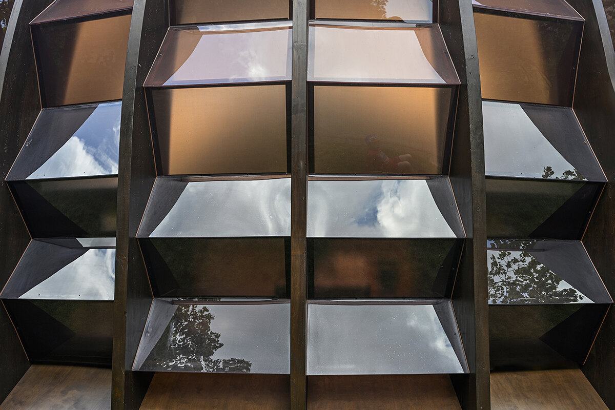 Dark shelving with sky reflected in each bay